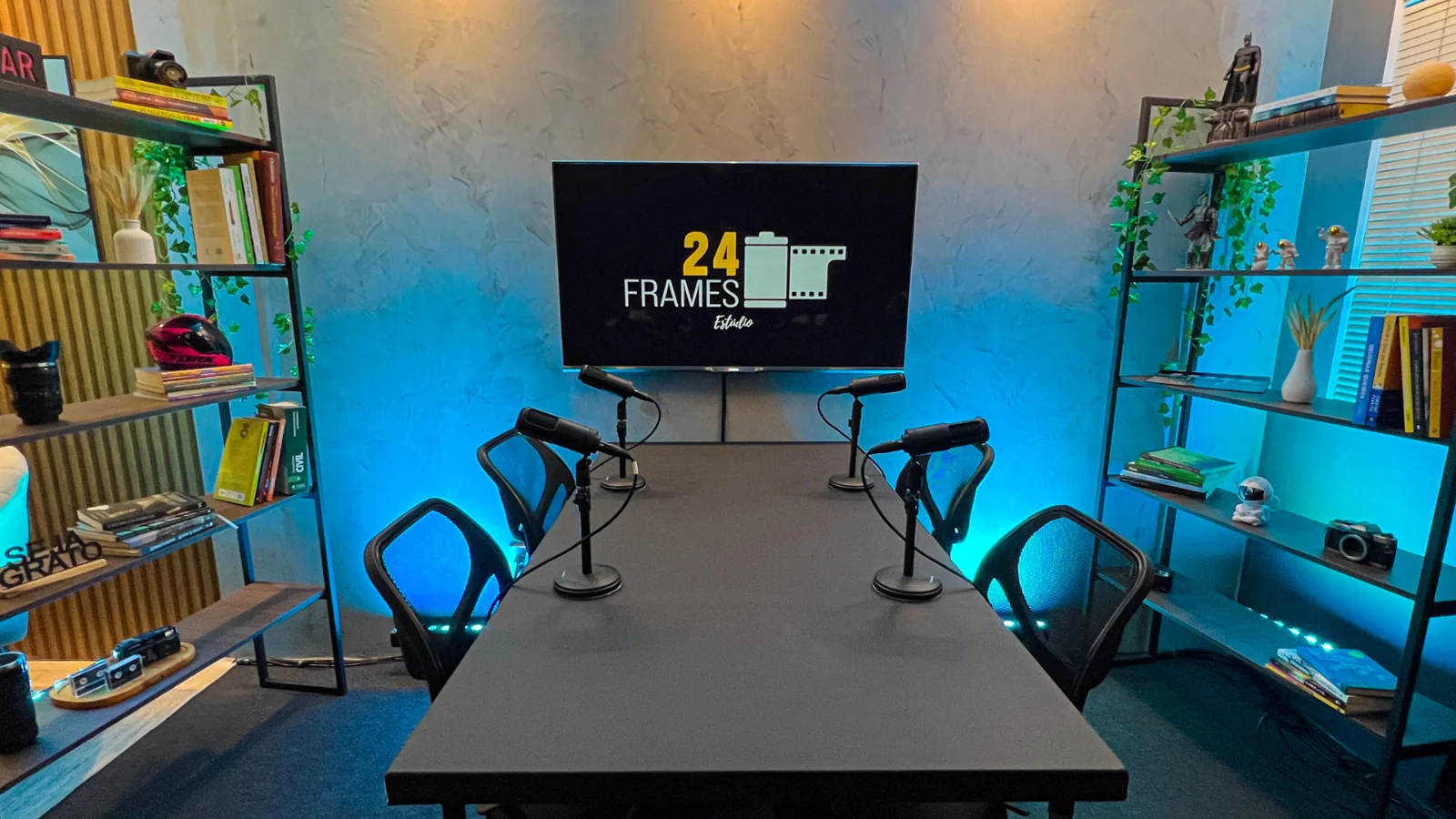 Estúdio 24 Frames com mesa, TV e quatro microfones